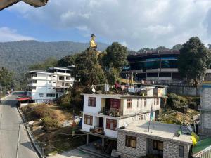 a city with a statue on top of a building at Hangkhim Homestay in Ravangla