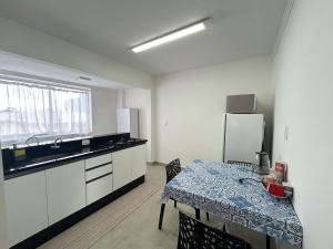 a kitchen with a table and a kitchen with a refrigerator at Ed Las Vegas by Select Stays in Chapecó