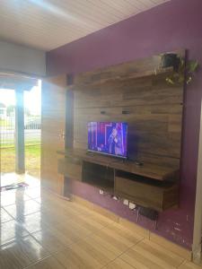 a living room with a tv on a wooden wall at Posada - Letiéle in São Gabriel