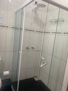 a shower with a glass door in a bathroom at Posada - Letiéle in São Gabriel