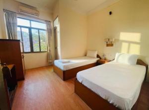a hotel room with two beds and a window at Bhuddha Bhoomi Lodge in Rummindei