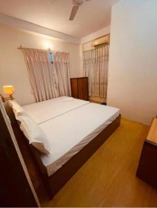 a bedroom with a large white bed in a room at Bhuddha Bhoomi Lodge in Rummindei