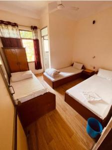 a room with two beds and a window at Bhuddha Bhoomi Lodge in Rummindei