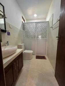 a bathroom with a sink and a toilet and a shower at Serene View Lodge in Unawatuna
