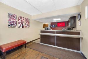 a waiting room with a bench and a cash register at HomeTowne Studios by Red Roof Buffalo - Niagara Airport in Williamsville