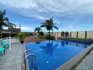 a large swimming pool with blue water in a yard at Homestay Aesthetic Jogja in Gondowulung