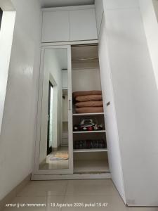 a white cabinet with a mirror in a room at Homestay Aesthetic Jogja in Gondowulung +19 photos