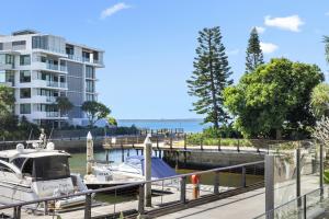 a boat docked at a marina next to a building at Allisee Apartments in Gold Coast