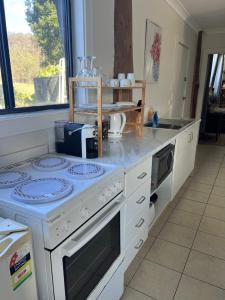 a kitchen with a counter with a stove top oven at Mulla Villa Farm cottage 1 in Wollombi