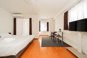 a bedroom with a bed and a desk and a tv at Kamata Opus2 Apartment in Tokyo