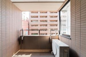 a bathroom with a toilet and a window at Kamata Opus2 Apartment in Tokyo