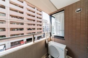 a balcony with a toilet and a building at Kamata Opus2 Apartment in Tokyo +115 photos