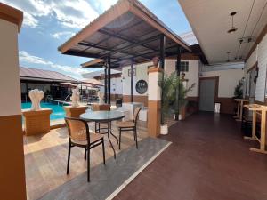 a patio with a table and chairs and a pool at Jin Pool Villa in Ban Khok Chakohan