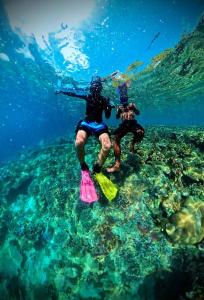 two people standing in the water in the ocean at Frits Homestay in Kri