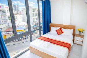 a bedroom with a bed and a large window at Gia Bảo Hotel Thủ Đức in Ho Chi Minh City