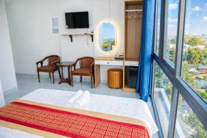a bedroom with a bed and a table and chairs at Gia Bảo Hotel Thủ Đức in Ho Chi Minh City