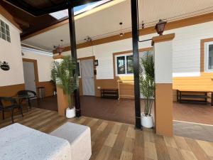 a living room with a couch and potted plants at Jin Pool Villa in Ban Khok Chakohan