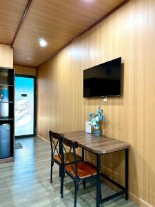 a dining room table with a television on a wall at The mountain Seaview in Vung Tau