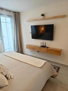 a bedroom with a flat screen tv on the wall at Comfy Habitación en Puebla! in San Baltasar