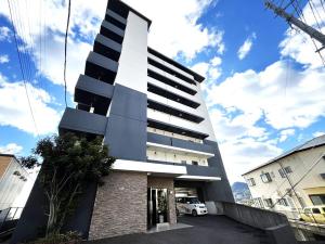 a tall building with a car parked in front of it at stayin at Imafuku in Sasebo