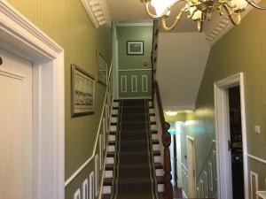 a stairway with green walls and a chandelier at Balham Lodge in London