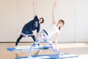 a man and a woman doing yoga on surfboards at ウェルネスハウスさらい in Nomi