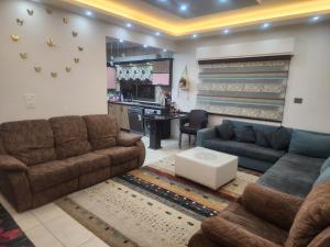 a living room with two couches and a kitchen at A big Family nice sunset flat in Amman