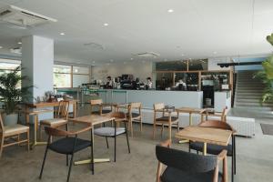 a restaurant with wooden tables and chairs and a counter at Good Fellows Resort in Kagoshima
