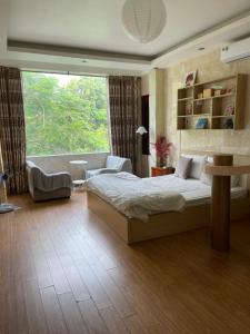 a bedroom with a bed and a large window at Duyen Motel in Hanoi