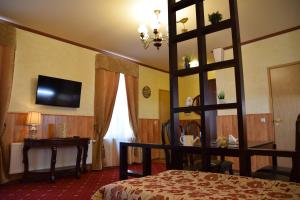 a hotel room with a bed and a desk and a television at Hansa Apartment in Tartu