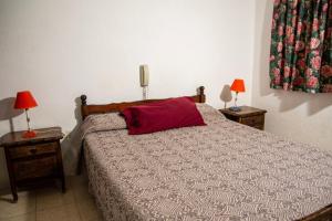 a bedroom with a bed with a red pillow on it at Hotel Barcelona in General Alvear +18 photos