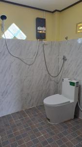 a bathroom with a toilet and a tv on the wall at Riverside Bungalow Don Det in Don Det