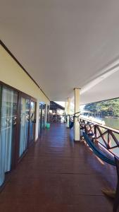 a dock with a hammock on the side of a building at Riverside Bungalow Don Det in Don Det