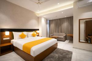 a hotel room with a large bed and a mirror at Solasta Stays and Banquet - Wakad in Pune +26 photos