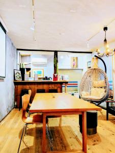 a living room with a wooden table and a chair at Kaido Urasa CoLiving in Minami Uonuma