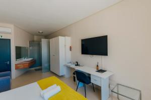 a bedroom with a desk and a tv on a wall at Grande Hotel in Vosburg