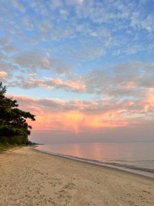 a beach with a cloudy sky and the ocean at Baan Phakdee in Ban Phlong Takhe