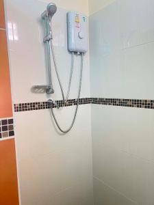a shower in a bathroom with a hand dryer on the wall at Baan Phakdee in Ban Phlong Takhe +8 photos