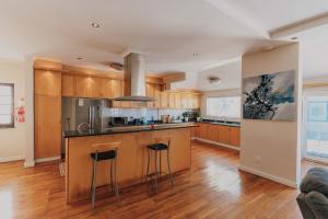 a kitchen with wooden cabinets and a island with bar stools at Grande Hotel in Vosburg