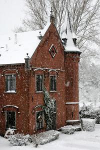 une maison en briques rouges avec de la neige dans l'établissement Un Air de Château, à Spa