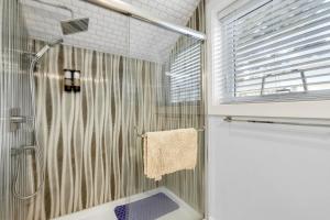 a shower with a glass door in a bathroom at New laneway house near Airport, World Cup stadium, Downtown, UBC in Vancouver