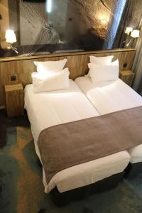 a hotel room with two beds and two lamps at Le Saint Aubert in Le Mont Saint Michel