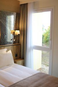 a bedroom with a bed and a large window at Le Saint Aubert in Le Mont Saint Michel