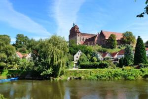 un castello in cima a una collina vicino a un fiume di Ferienwohnung Wolf a Havelberg