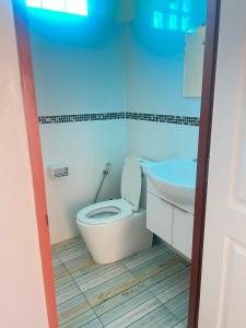 a bathroom with a toilet and a sink at Baan Phakdee in Ban Phlong Takhe
