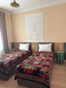 two beds in a hotel room with two at KALA Khiva in Khiva +70 photos