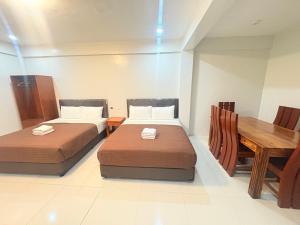 a room with two beds and a wooden table at Guest hotel Palestina Pili in Pili +28 photos