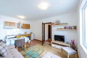 a living room with a table and a kitchen at Apartments Aida in Cavtat