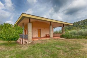 a small house with a porch and a grass field at Villa Chiara in Bracciano