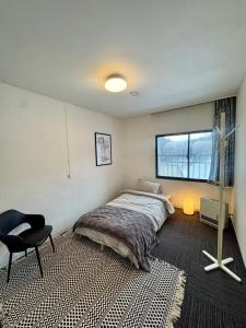a bedroom with a bed and a chair in it at Chill House in Myoko